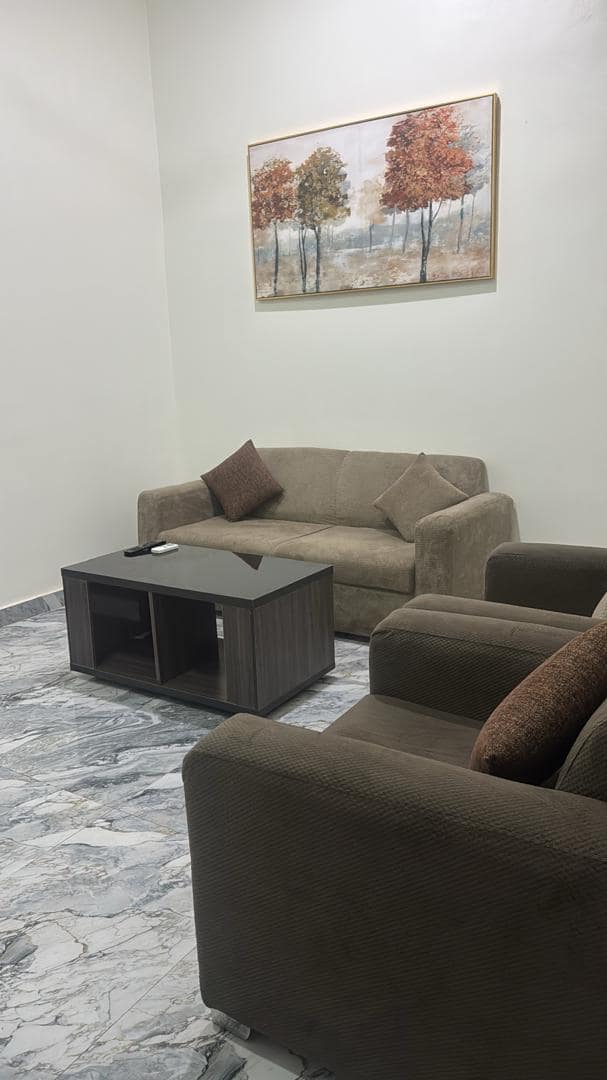 Business suite sitting area with sofa, armchairs and framed painting