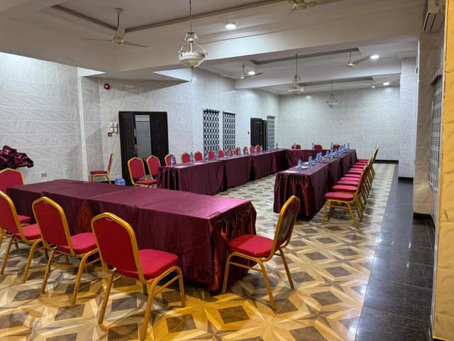 Conference hall in a U-shaped layout with water bottles on each table