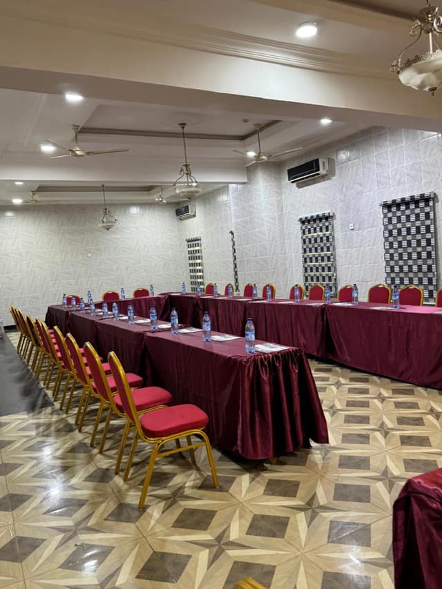 Conference hall with classroom-style tables and red chairs