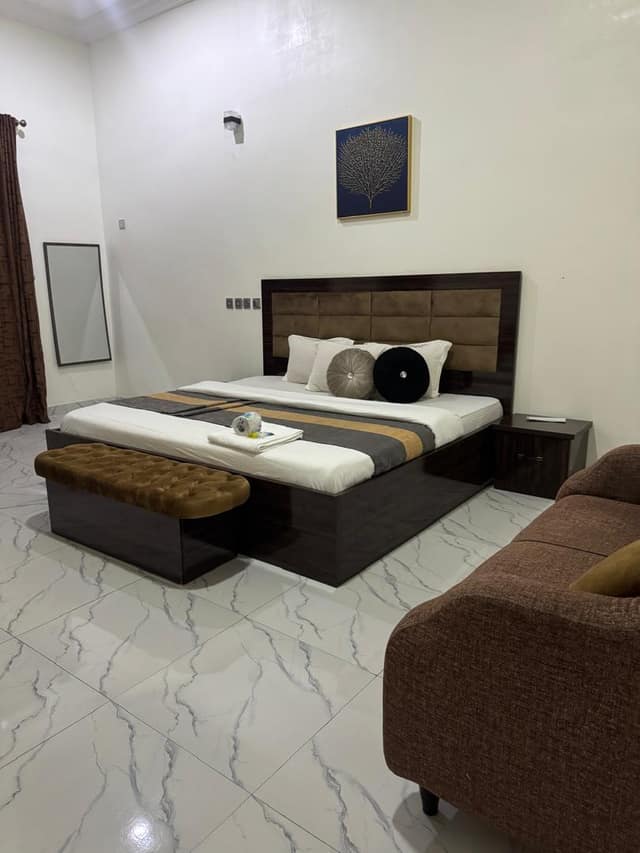 Executive room with bed, bench and sitting area