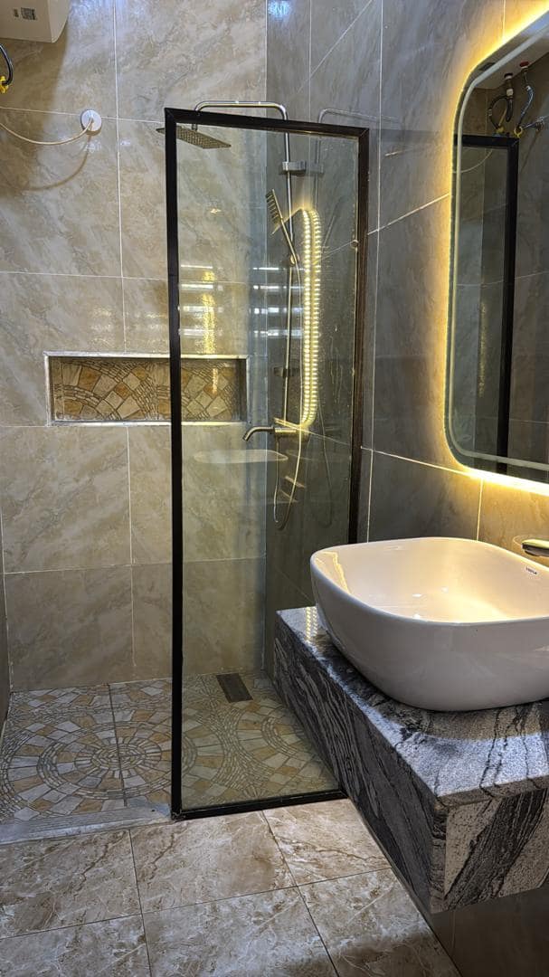 Executive room bathroom with glass shower and illuminated mirror