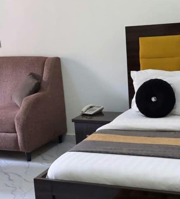 Bedroom with brown headboard and armchair