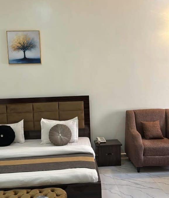 Bedroom with tufted bench and framed tree painting